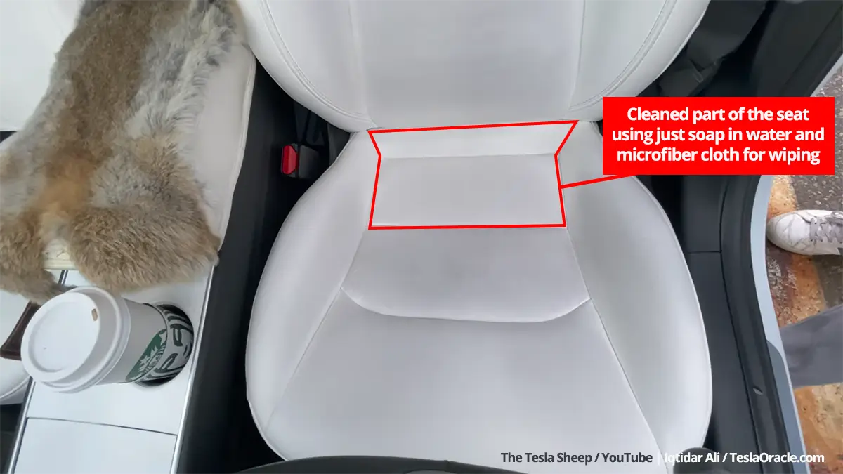Comparison of the cleaned and stained part of a white Tesla seat using only soap, water, and a soft cloth.