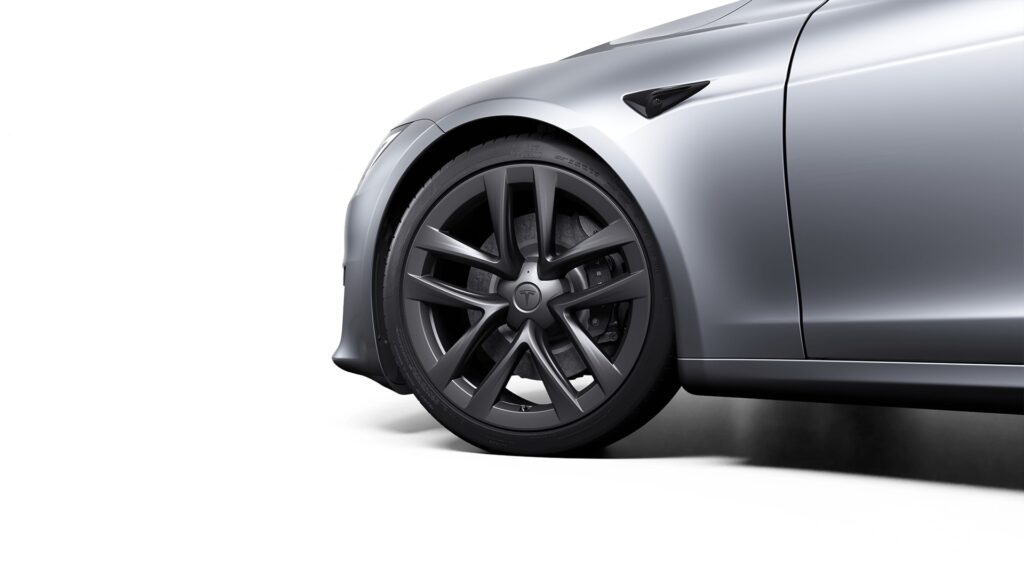 Closeup of a Tesla Model S front fender in Lunar Silver color with 21″ Arachnid Wheels.