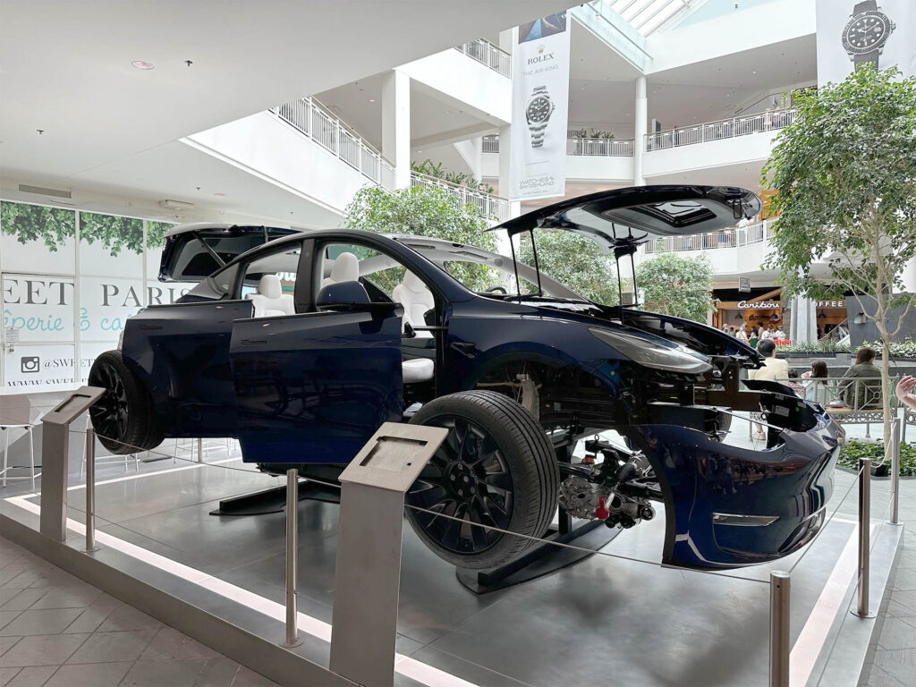 An exploded Tesla Model Y electric SUV on display at the Mall of America in Bloomington, Minnesota. The front driving unit (electric motor) is visible from this angle. 