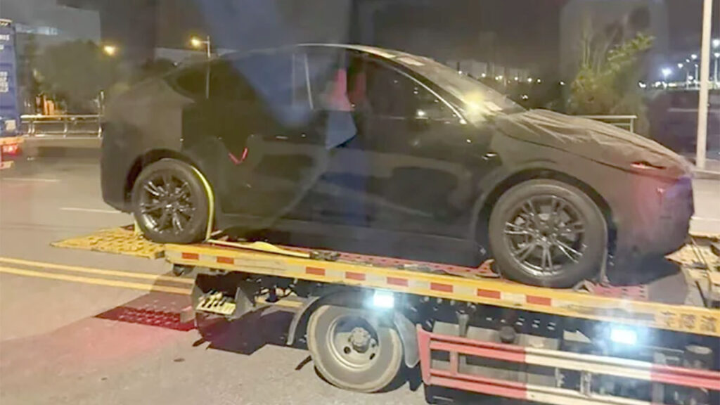 Tesla Model Y Juniper loaded on a vehicle transport trailer at Giga Shanghai. Front and rear ends are wrapped to hide the design refresh changes.